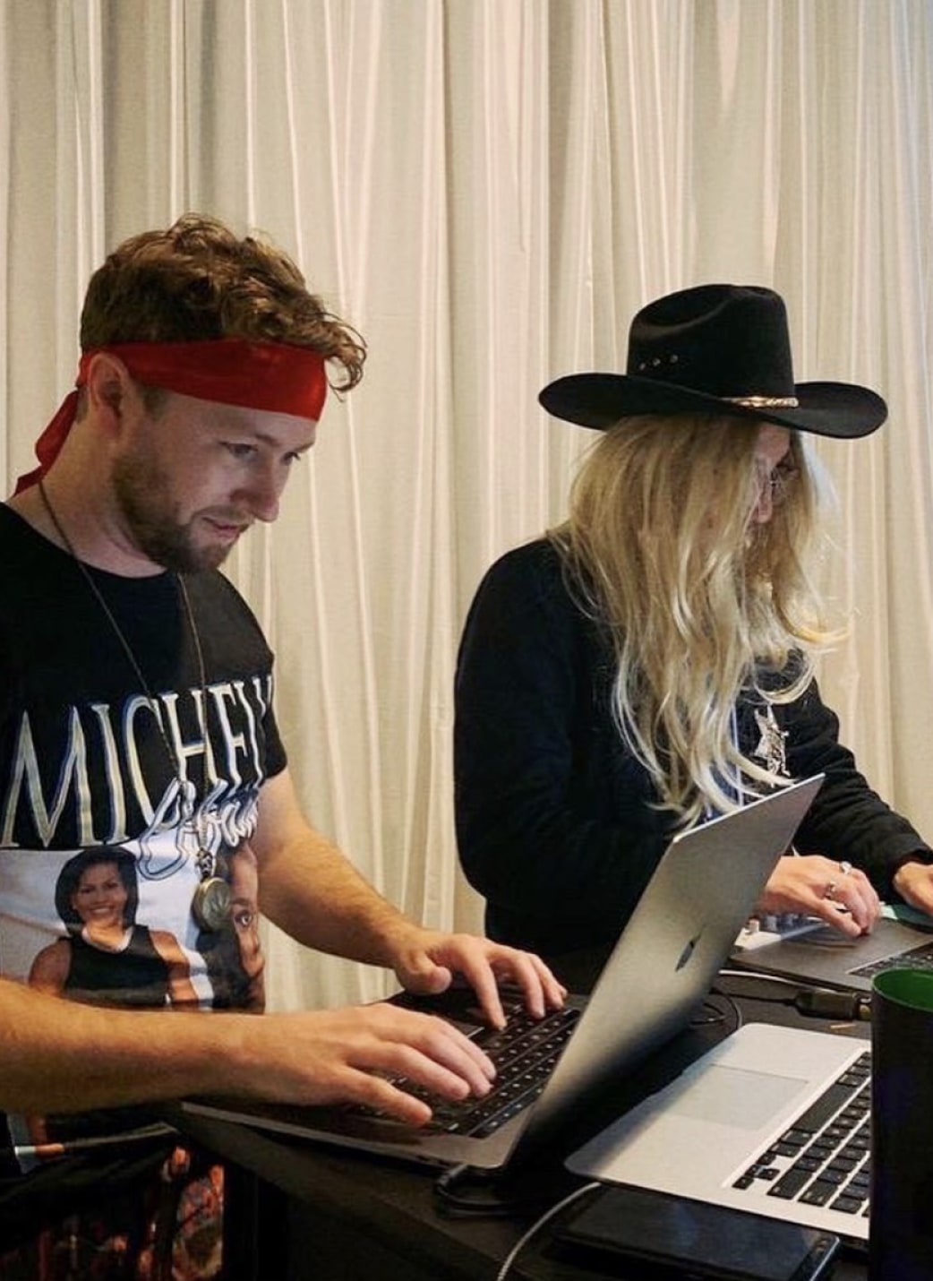 Two people running an event competition wearing wigs